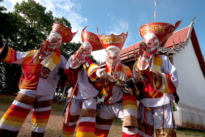 Group of people in traditional clothing against sky