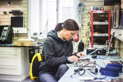 Serious mature woman working in computer workshop