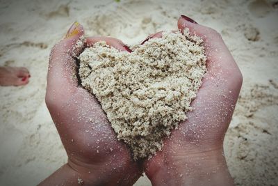 Close-up of hands holding sand