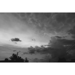 Silhouette of trees against cloudy sky