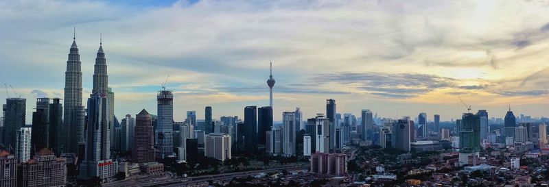 View of cityscape against cloudy sky