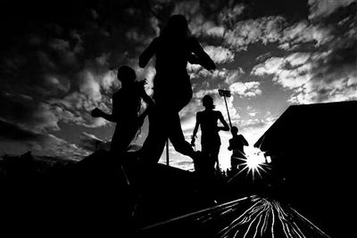 Low angle view of silhouette people against cloudy sky