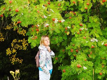 Full length of child standing on flowering plants