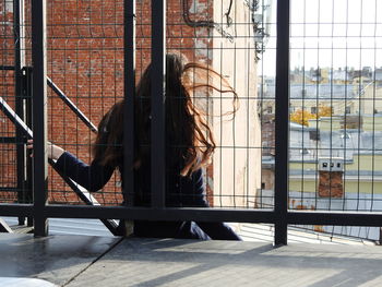 Woman seen through window on building