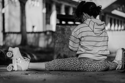 Rear view of woman sitting on floor