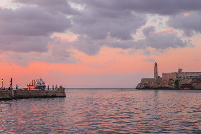 Scenic view of sea against cloudy sky during sunset