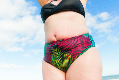 Natural summer bodies, diverse bodies, anti stereotypes. midsection of woman on beach against sky