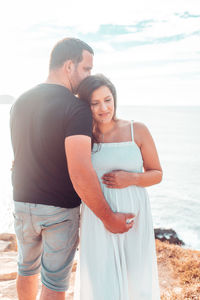 Smiling pregnant woman standing with husband