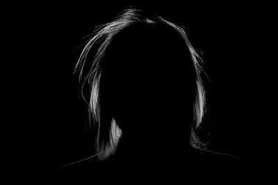 Rear view of woman against black background