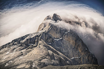 High angle view of mountain amidst fog against sky