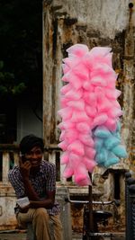 Smiling man talking on phone while selling cotton candy 