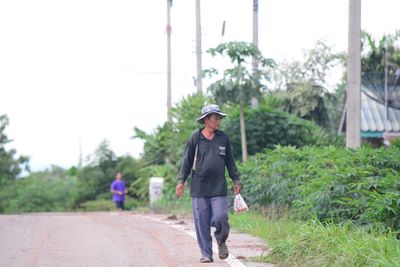 Rear view of boy walking on road