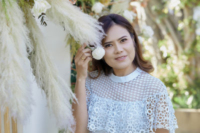 Portrait of smiling woman touching decorations