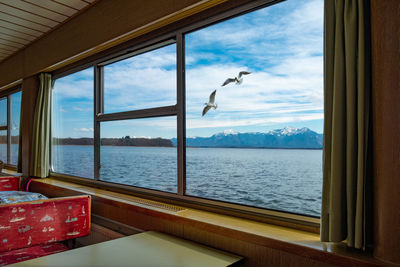 View of sea seen through glass window