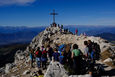 Group of people on rock against sky