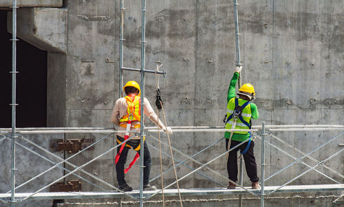 Man working with umbrella standing on metallic structure