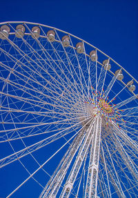 Low angle view of ferris wheel against blue sky