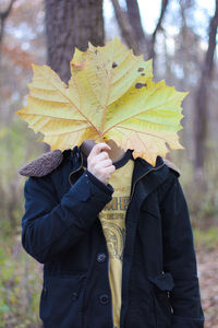Man holding leaf in front of face