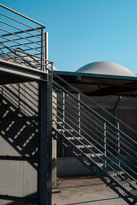 Low angle view of staircase against building against clear blue sky