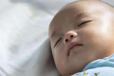 Close-up of baby sleeping on bed