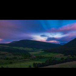 Scenic view of mountains against cloudy sky