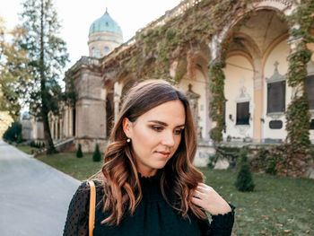 Portrait of beautiful woman standing against building