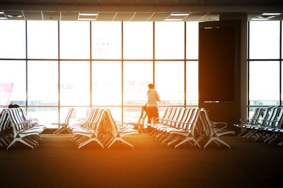 Man standing by seats at airport terminal