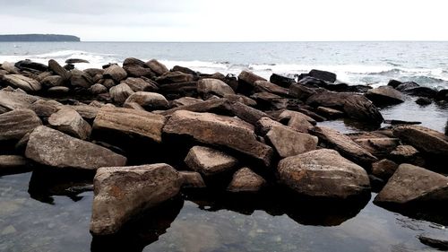 Rocks on beach against sky