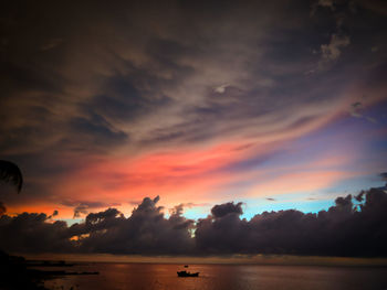 Scenic view of sea against dramatic sky during sunset