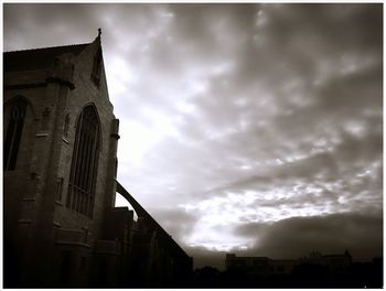 Low angle view of building against cloudy sky