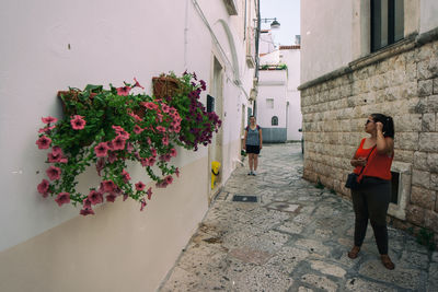 Full length of woman standing by flowering plants