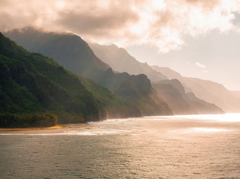 Scenic view of sea and mountains against sky