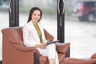 Portrait of a smiling young woman sitting outdoors