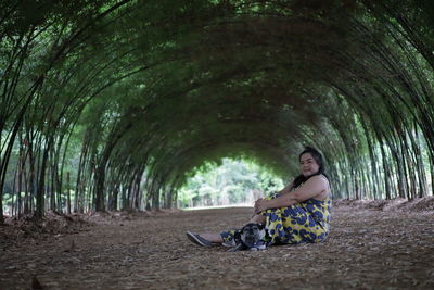 Portrait of woman with pug sitting on land