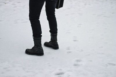 Low section of man standing on snow