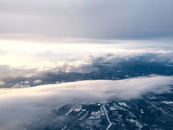 Aerial view of snow covered landscape against sky
