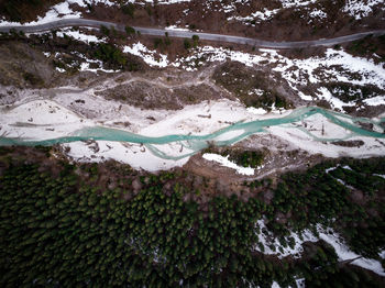 Drone view of river by trees in forest during winter