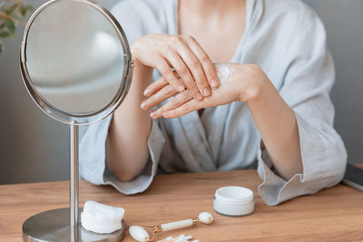 Midsection of woman holding while sitting on table