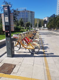 Bicycles on street in city against sky