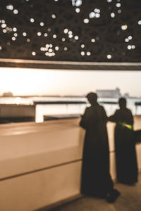 Defocused image of people on illuminated street