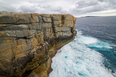 Rock formations by sea against sky