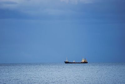Ship sailing on sea against blue sky