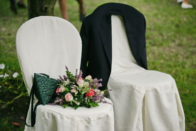Bouquet and bag on chair during wedding ceremony