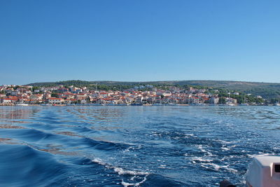 Sailing on motor boat on adriatic sea with primosten cityscape in the background