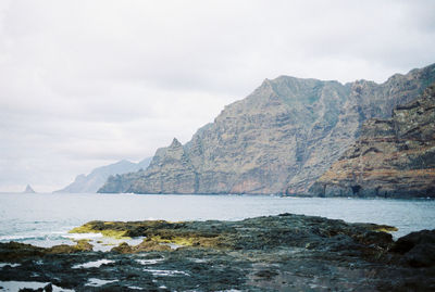 Scenic view of sea and mountains against sky