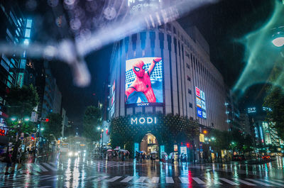 Panoramic view of people in illuminated city at night