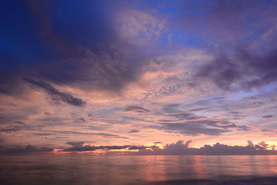 Scenic view of sea against dramatic sky during sunset