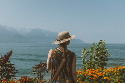 Rear view of woman standing at seashore 