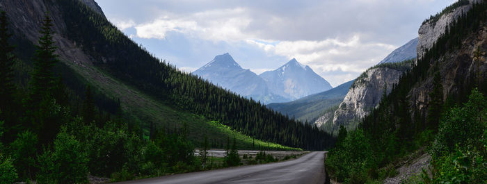 Panoramic view of country road by mountains against sky