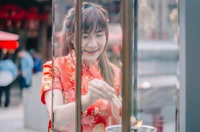 Smiling young woman burning incense